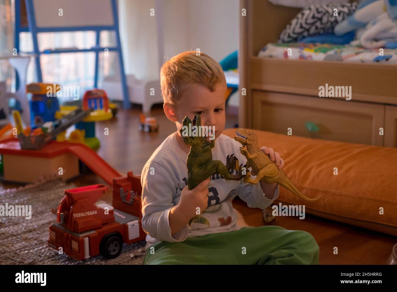 Cute creative and curious little boy playing with his toy's Stock Photo