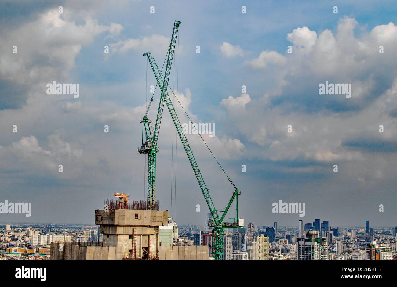 Construction crane or climbing crane on a roof of a high-rise project to be completed Stock Photo