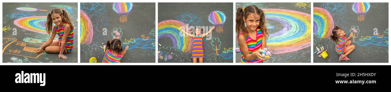 Child draws collage with chalk on the asphalt. Selective focus. Kid. Stock Photo