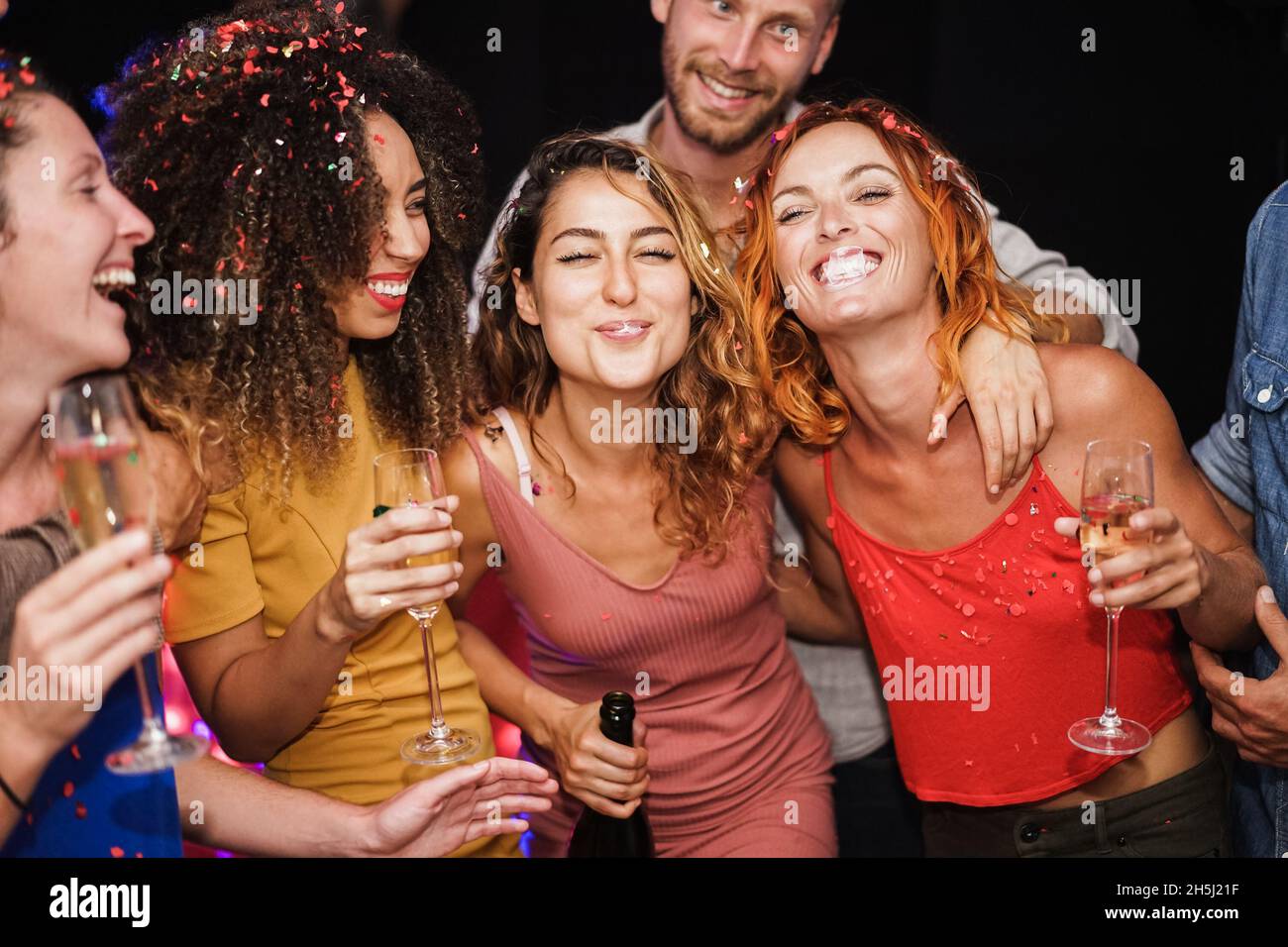 Young multiracial friends dancing and drinking champagne at weekend ...