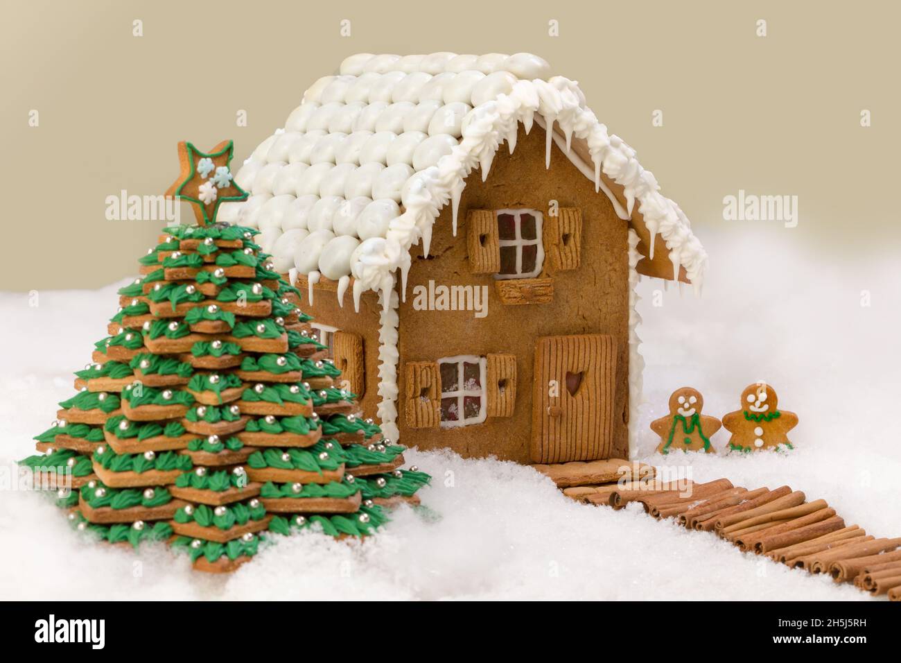 Cookie christmas tree and gingerbread house in a snow landscape Stock