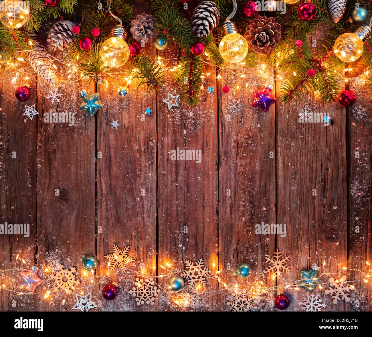 Christmas - Decoration On Wooden Illuminated With Lights With Fir Branches And Ornaments Stock Photo
