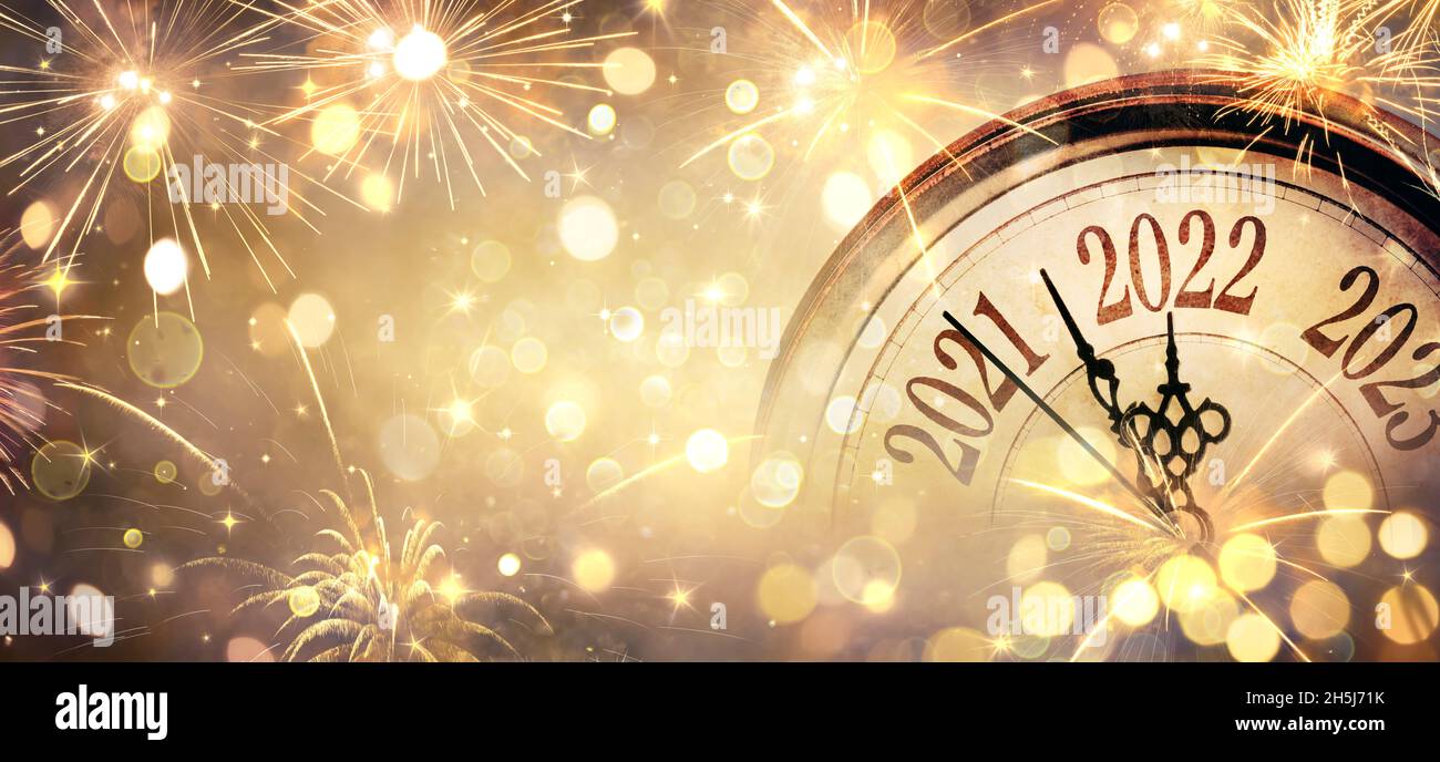 2022 New Year - Clock And Fireworks - Countdown To Midnight - Golden Abstract Defocused Background Stock Photo