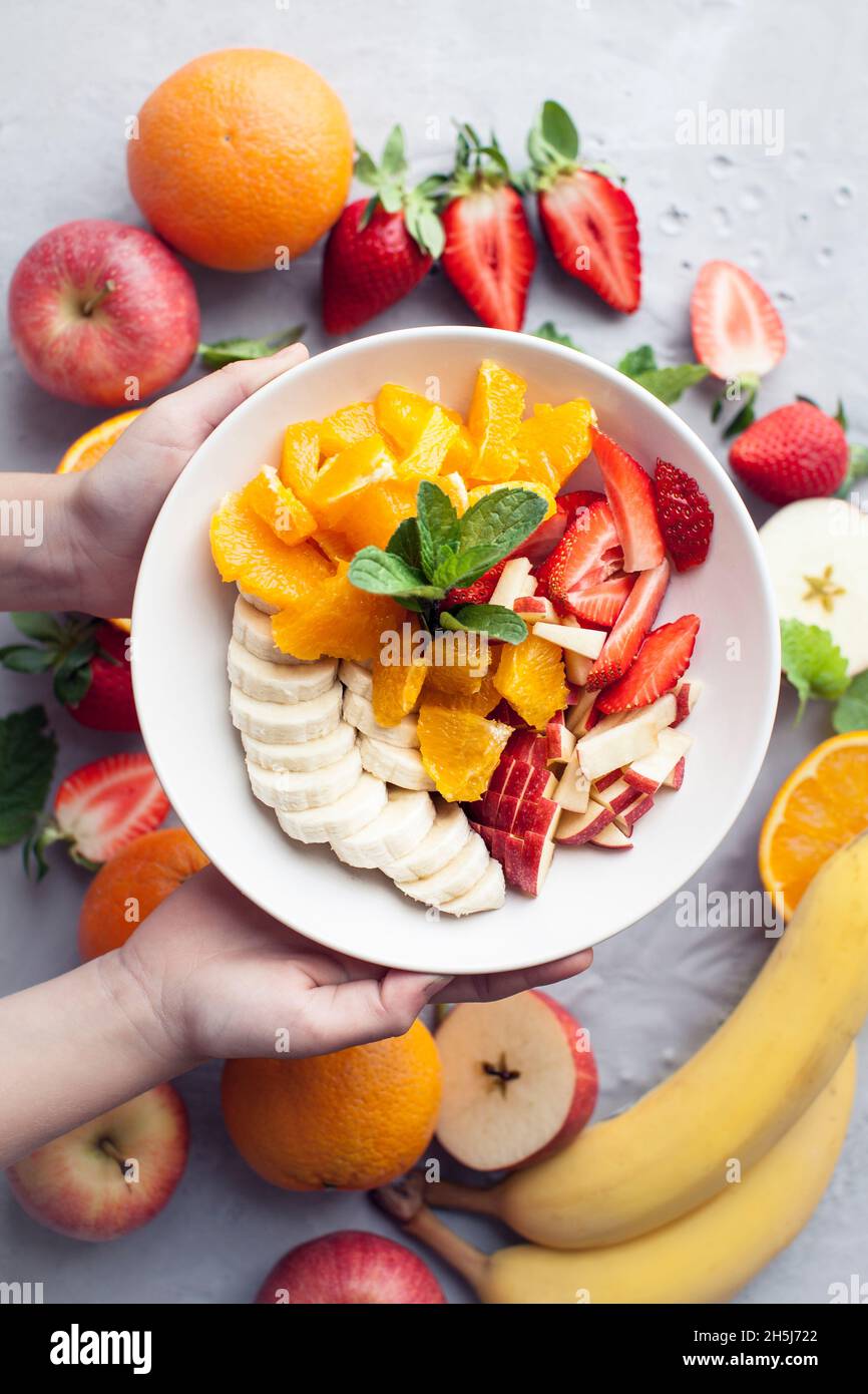 Fruit salad with oranges, bananas, apple and strawberries Stock Photo