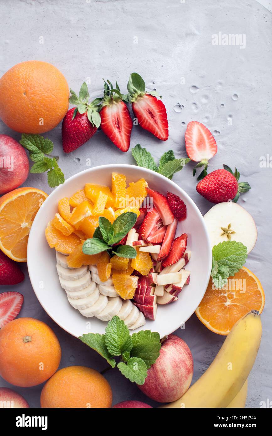Fruit salad with oranges, bananas, apple and strawberries Stock Photo
