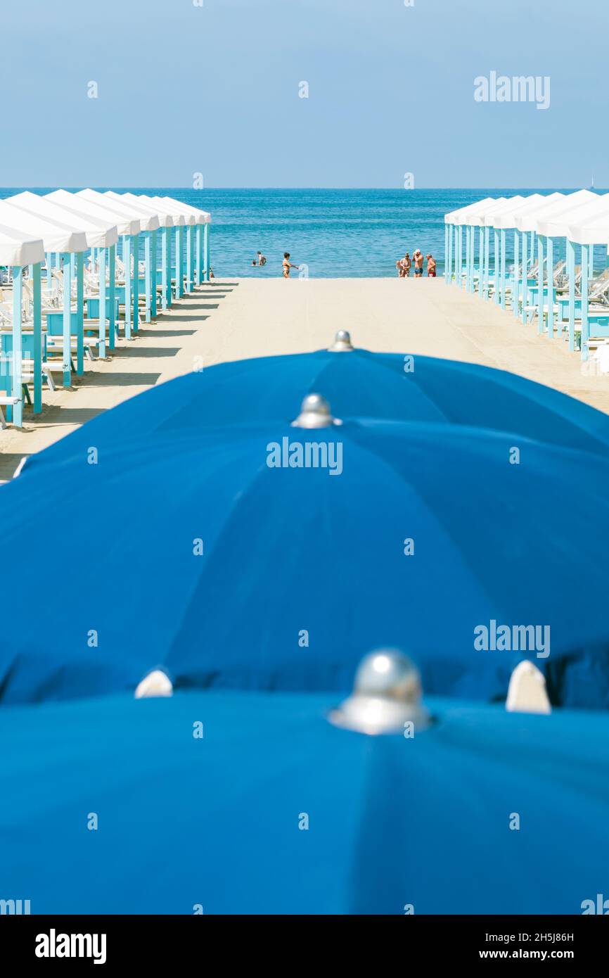An elevated view of Viareggio beach in Tuscany, Italy, with typical rows of umbrellas and tents looking towards the sea. Stock Photo