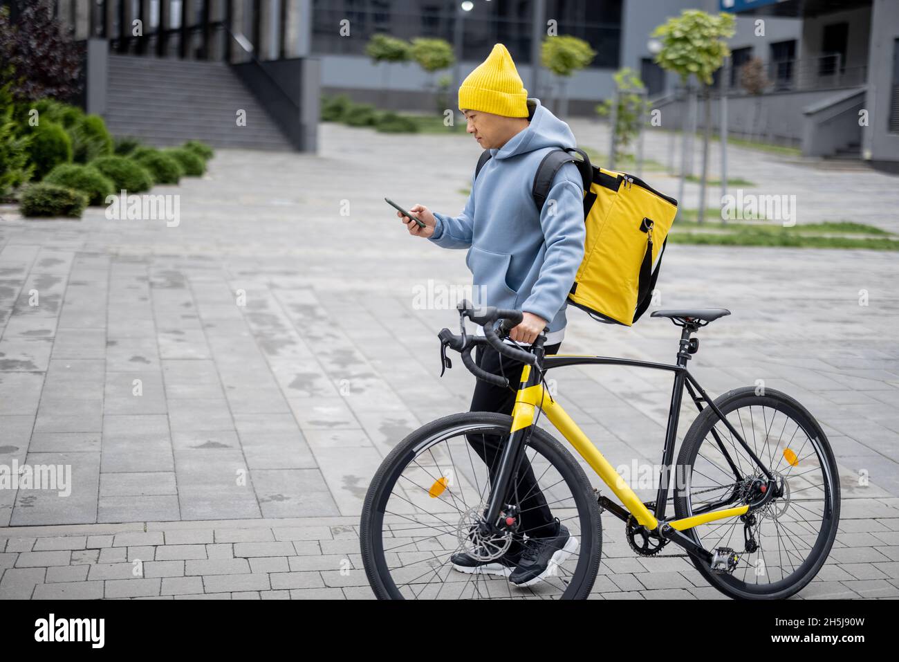Courier search client place on smartphone in city Stock Photo