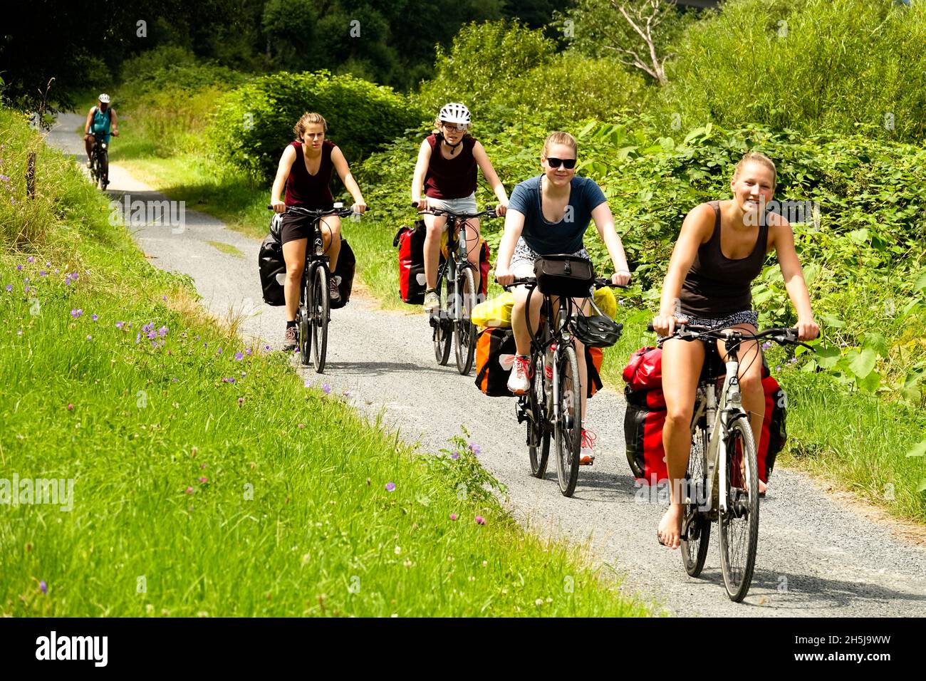 Women on bikes riding together through Elbe valley cycle route Saxony Germany nature summer trail women on bicycles Stock Photo