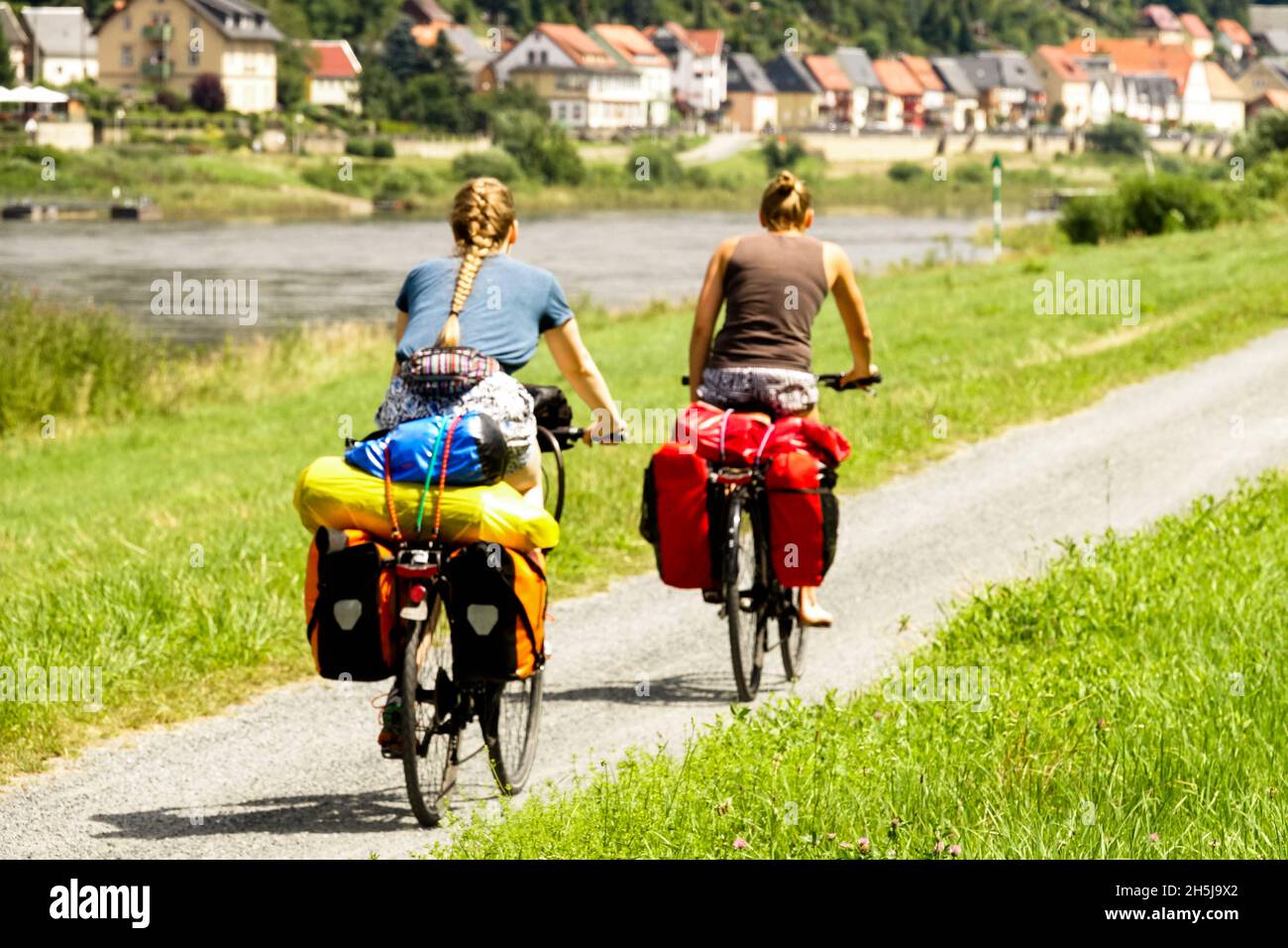 Women bike riding on cycle route in summer vacation Germany Saxony Elbe Valley river path Stock Photo