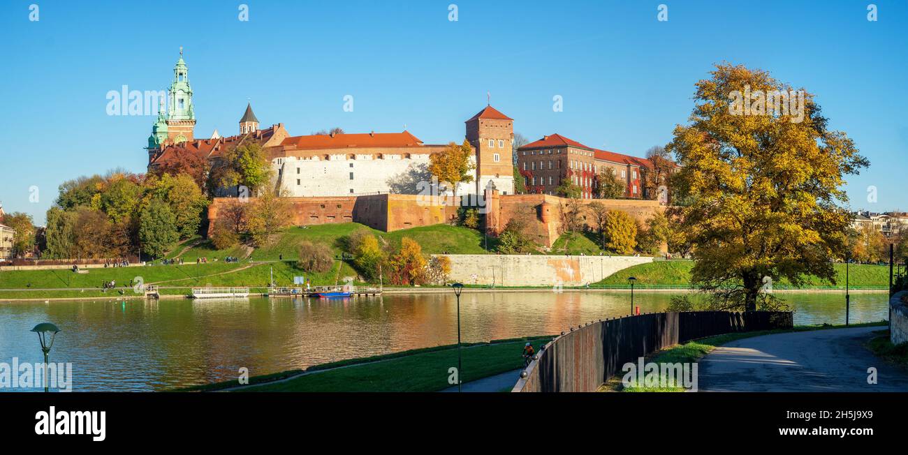 Krakow, Poland.  Panorama with Royal Wawel castle and cathedral, Vistula river, promenades and an autumn tree in,  in sunset light Stock Photo