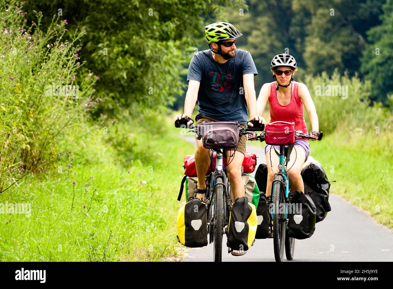 Couple riding bikes Germany summer vacation Man Woman on bicycles Stock Photo