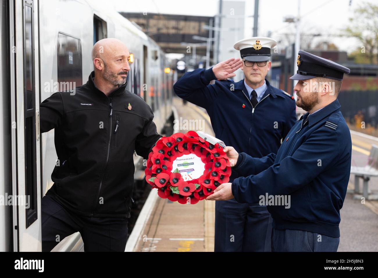 EDITORIAL USE ONLY Oliver Evans (right) and Steve King from RAF Henlow present Thameslink driver, Noel Hughes (left) with a poppy wreath at Bedford Station before he transports it to London, marking the rail operator's partnership with The Veterans Charity on the nationwide 'Routes of Remembrance' campaign, which sees poppy wreaths touring the country's railway network to Honour the Fallen. Picture date: Wednesday November 10, 2021. Stock Photo