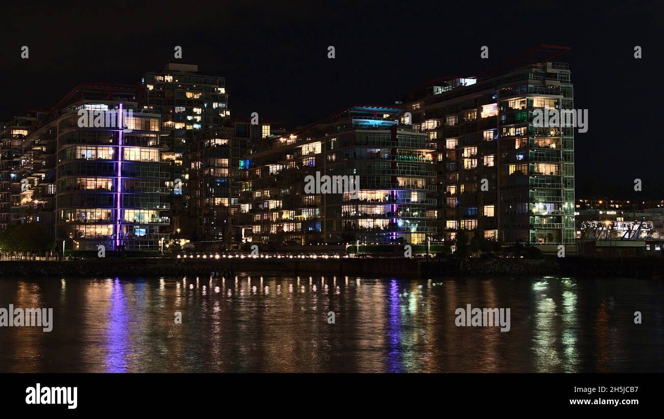 Beautiful night view of illuminated modern apartment buildings on the shore of Vancouver North, British Columbia, Canada near The Shipyards. Stock Photo