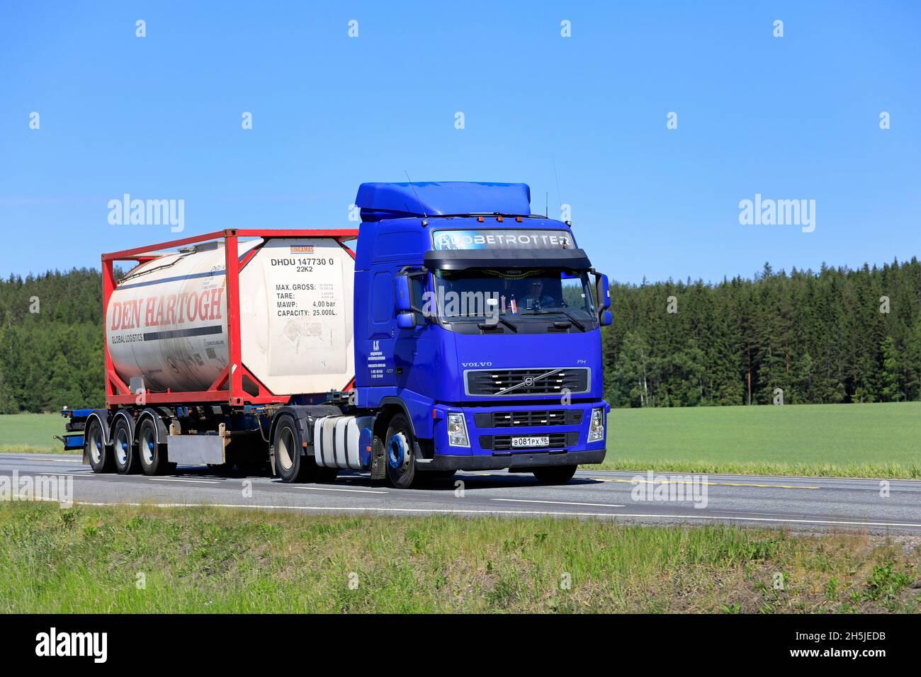 Blue Volvo FH truck transports Den Hartogh Global Logistics Singamas bulk container on highway 2 in the summer. Jokioinen, Finland. June 15, 2020. Stock Photo