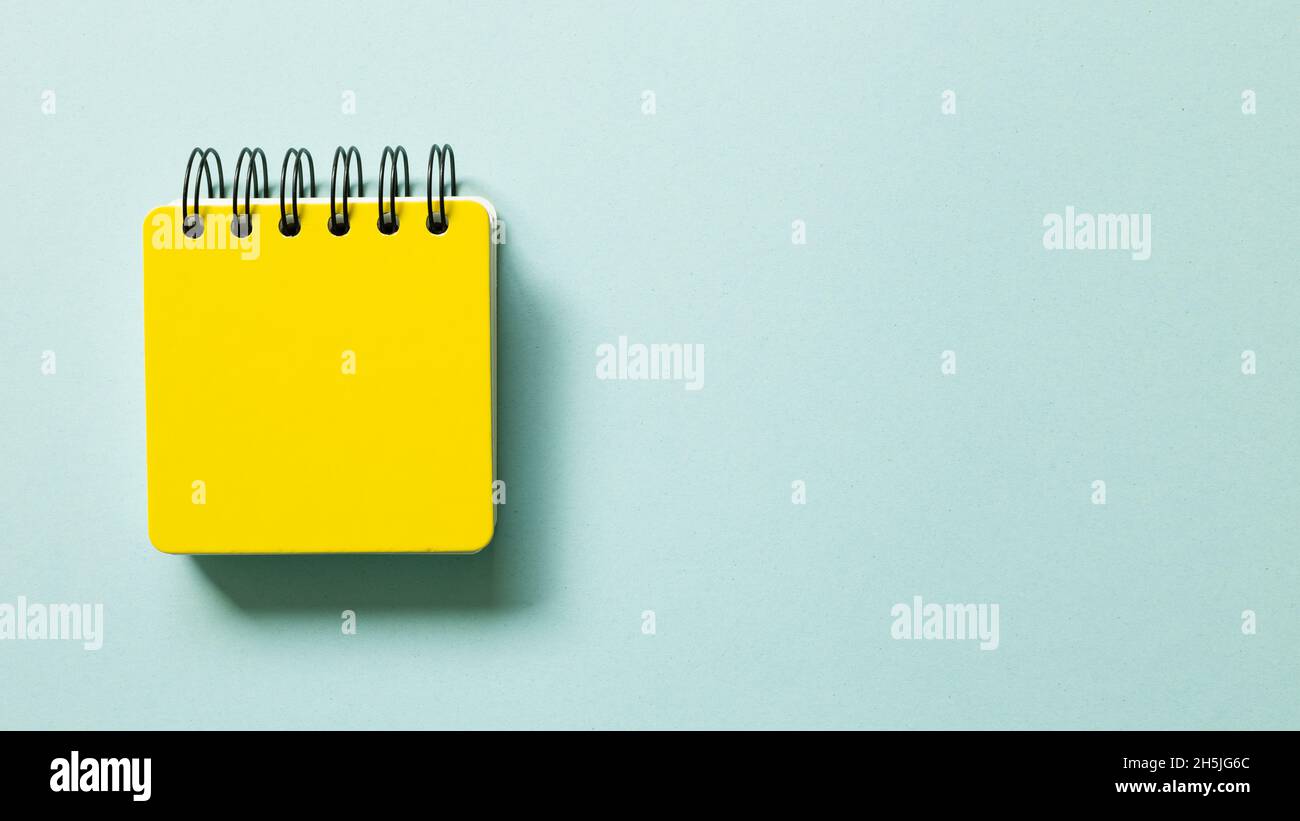 Yellow note pad isolated on blue background. top view, copy space Stock Photo