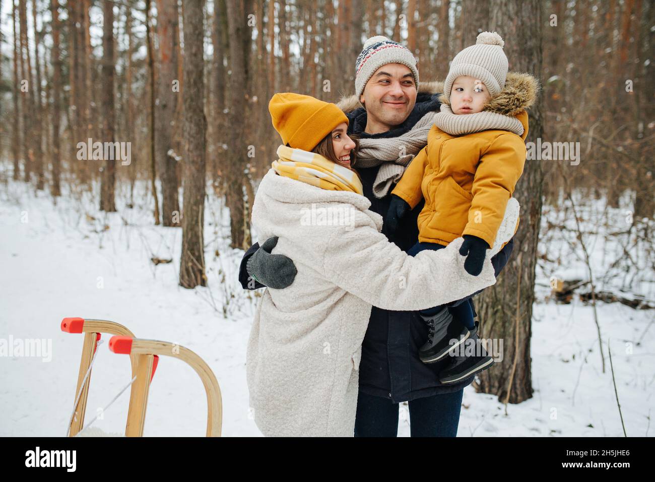 Family on Christmas Eve weekend walking through the winter forest.  Stock Photo