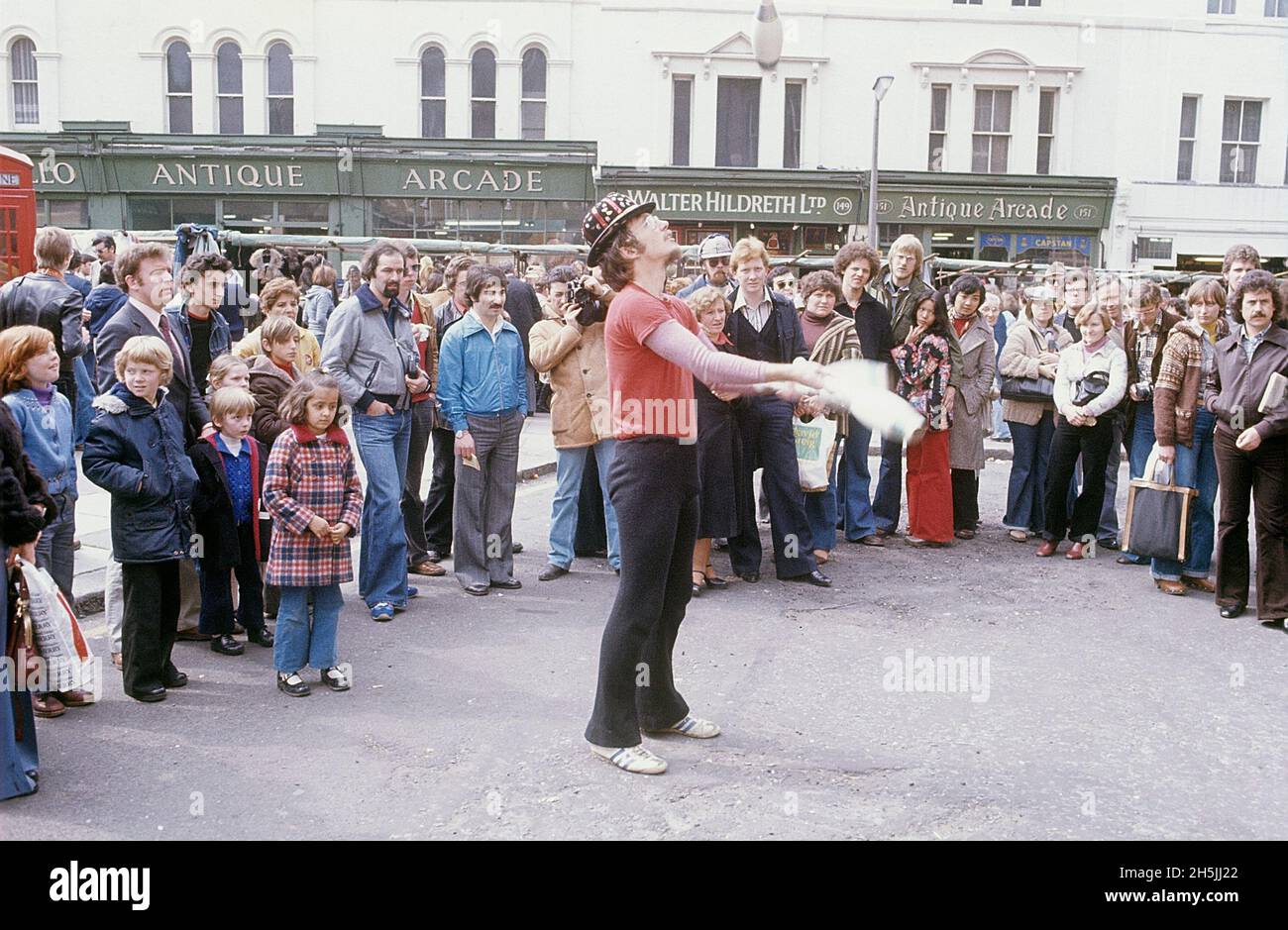 London 1982. A London street view and Portobello road where a juggler is seen performing for the people in the street. Credit Roland Palm. Stock Photo