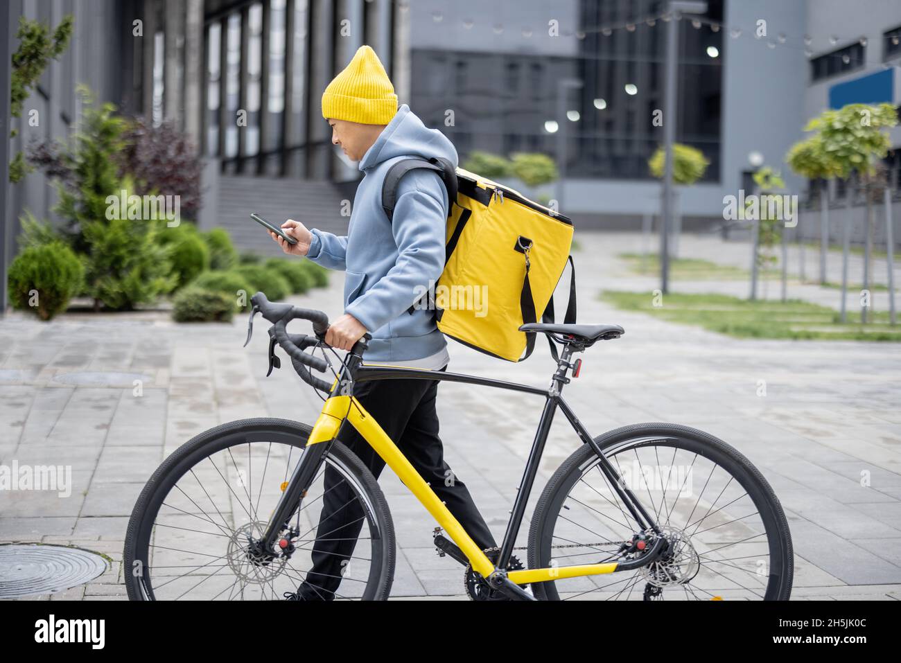 Courier search client place on smartphone in city Stock Photo