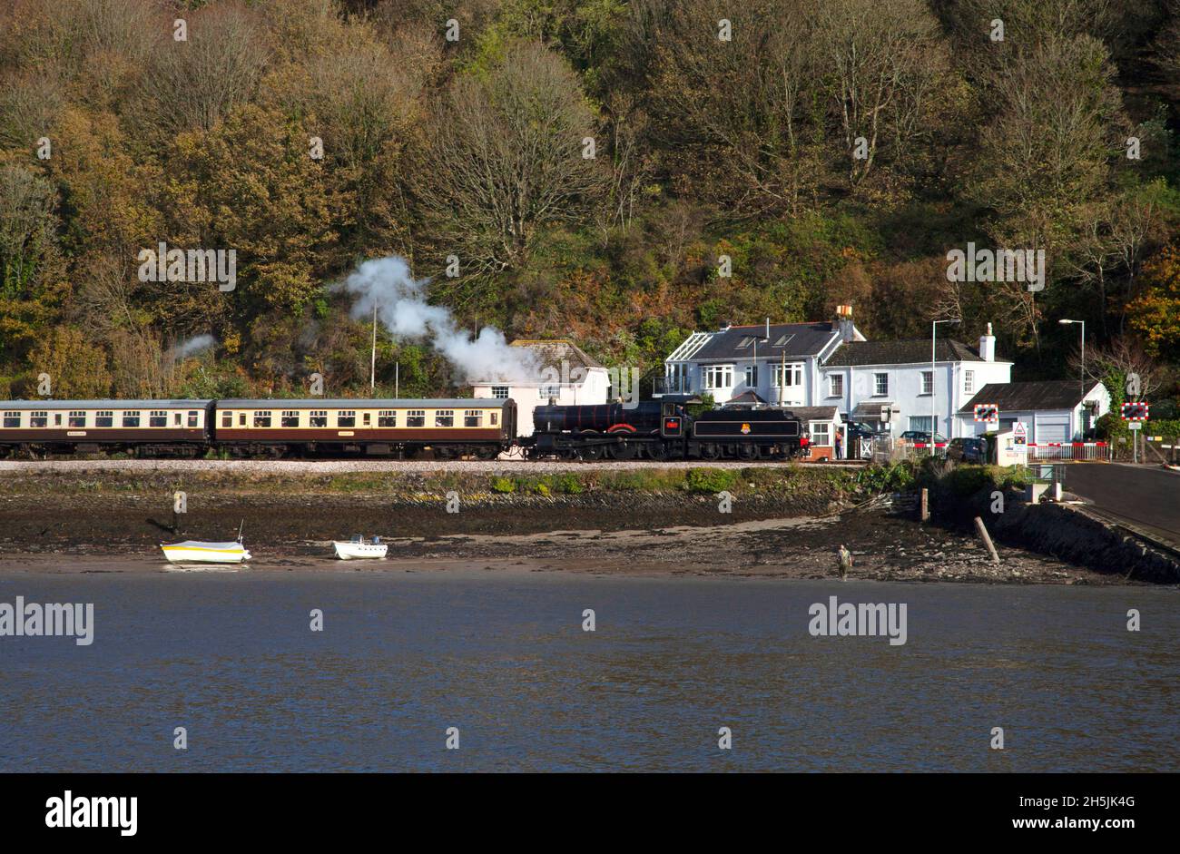 Dartmouth steam railway train engine locomotive carriages Autumn Fall leaves level crossing River Dart Devon copy space boats fisherman Stock Photo