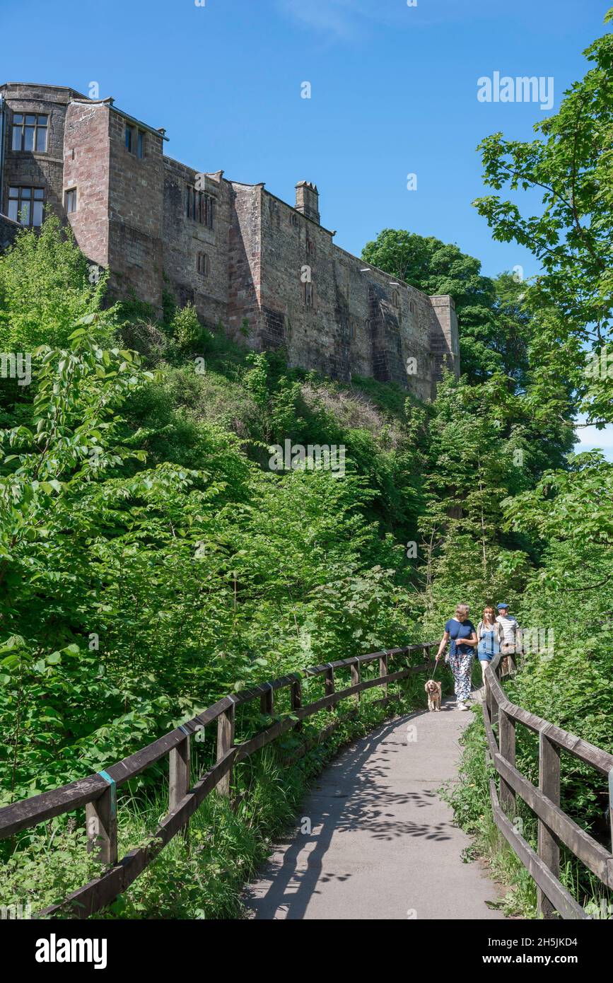 Skipton, view in summer of people walking on the footpath overlooking the Springs Branch Canal with the north wall of Skipton Castle above, Yorkshire Stock Photo