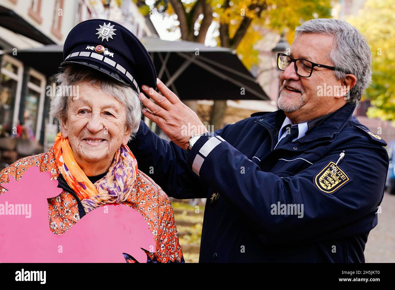 Weinheim, Germany. 10th Nov, 2021. Ingrid Noll, crime novelist, is given  her service cap by Siegfried Kollmar, Mannheim's police chief, at the  opening of the "Ingrid Noll Trail" named after her. At