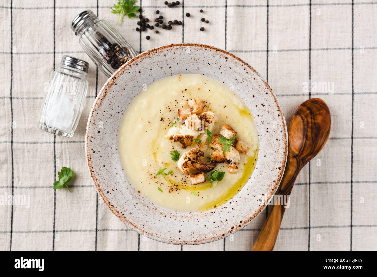 Cauliflower cream soup with croutons and olive oil in a bowl, table top view. Healthy warm soup bowl Stock Photo