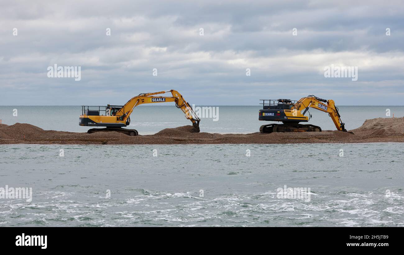 Heavy digging and moving machinery seen working on Pagham Spit. Stock Photo