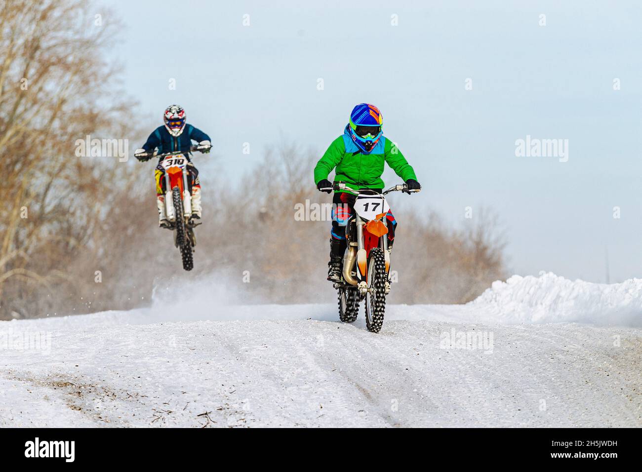 two motorcyclists riding on snowy trail winter motocross Stock Photo
