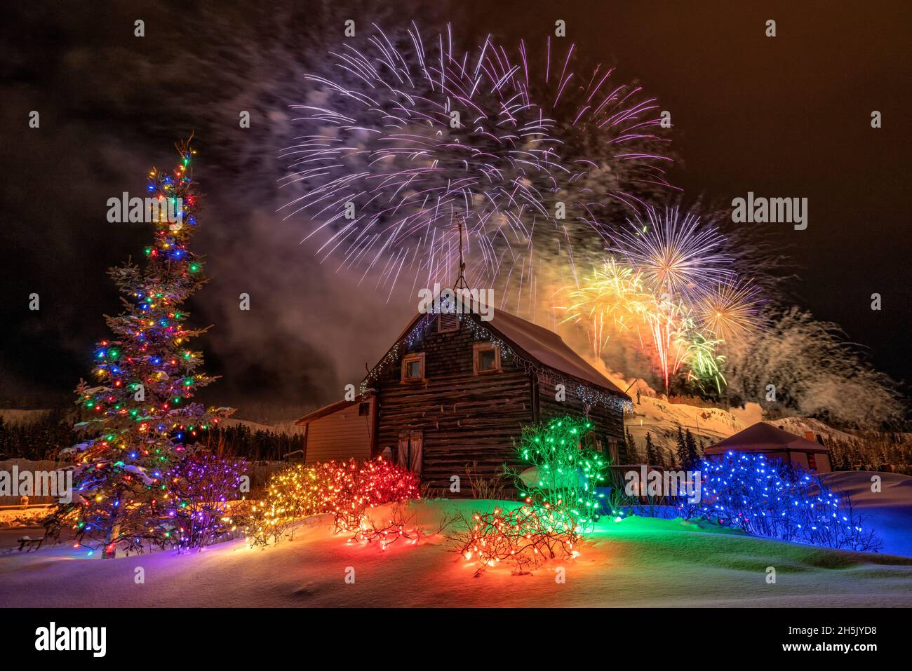 Fireworks explode overtop of a cabin during Yukon Sourdough Rendezvous