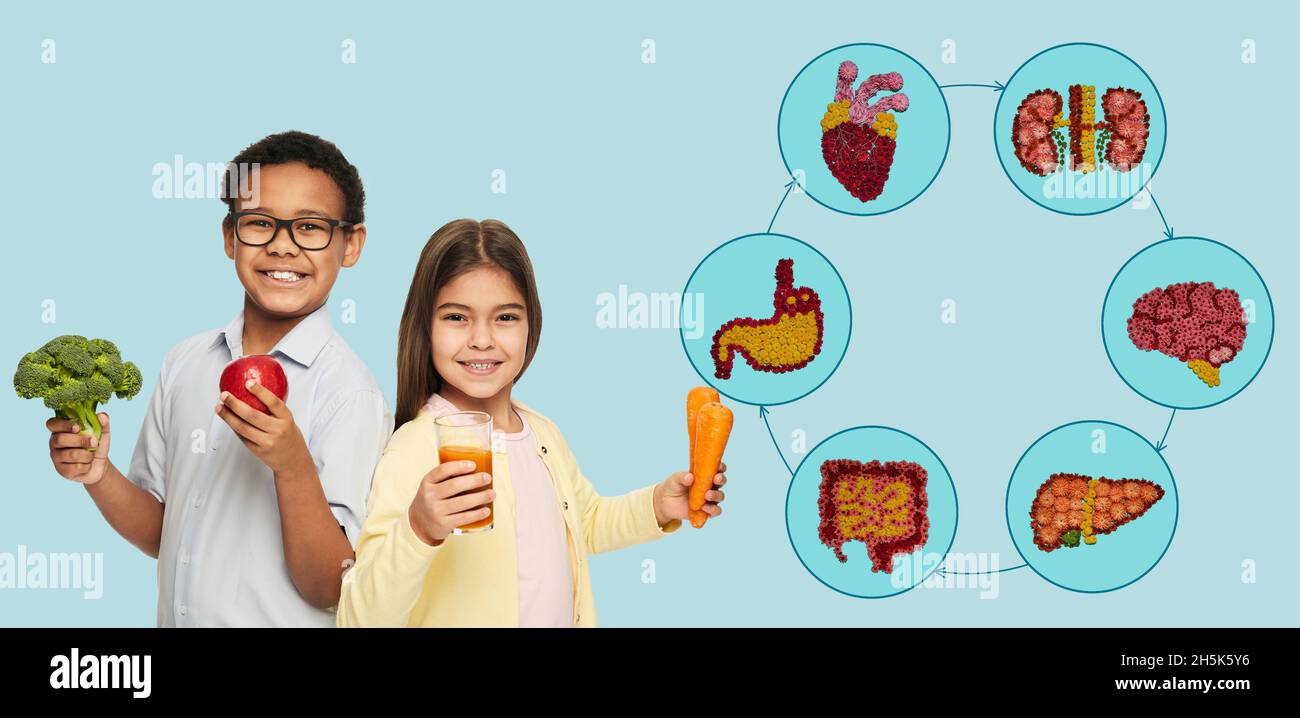 Multi-ethnic group of children with healthy vegetables, fruits, and carrot juice. Advertising children healthy nutrition Stock Photo
