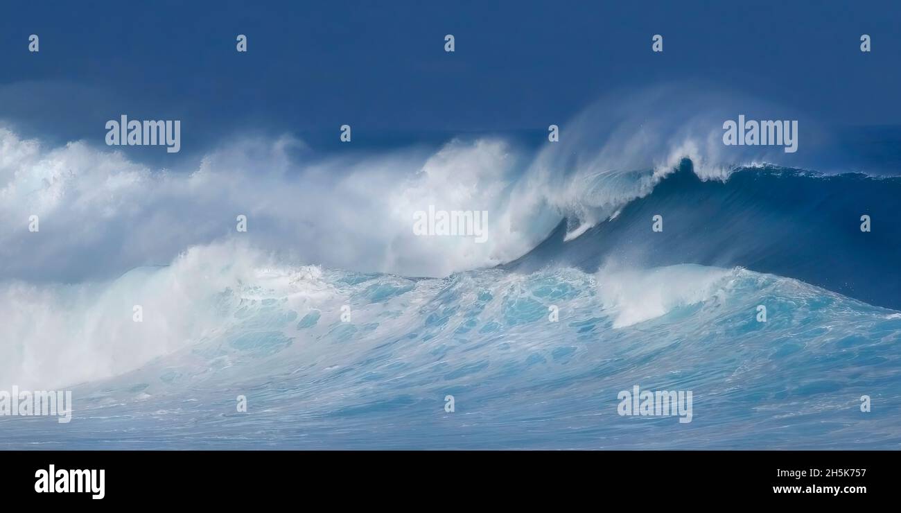 White water froth of large, breaking waves crashing in the ocean with a dark sky; Hawaii, United States of America Stock Photo