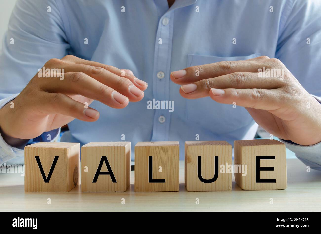 Hand businessman wooden cube value text. Business concept Stock Photo ...