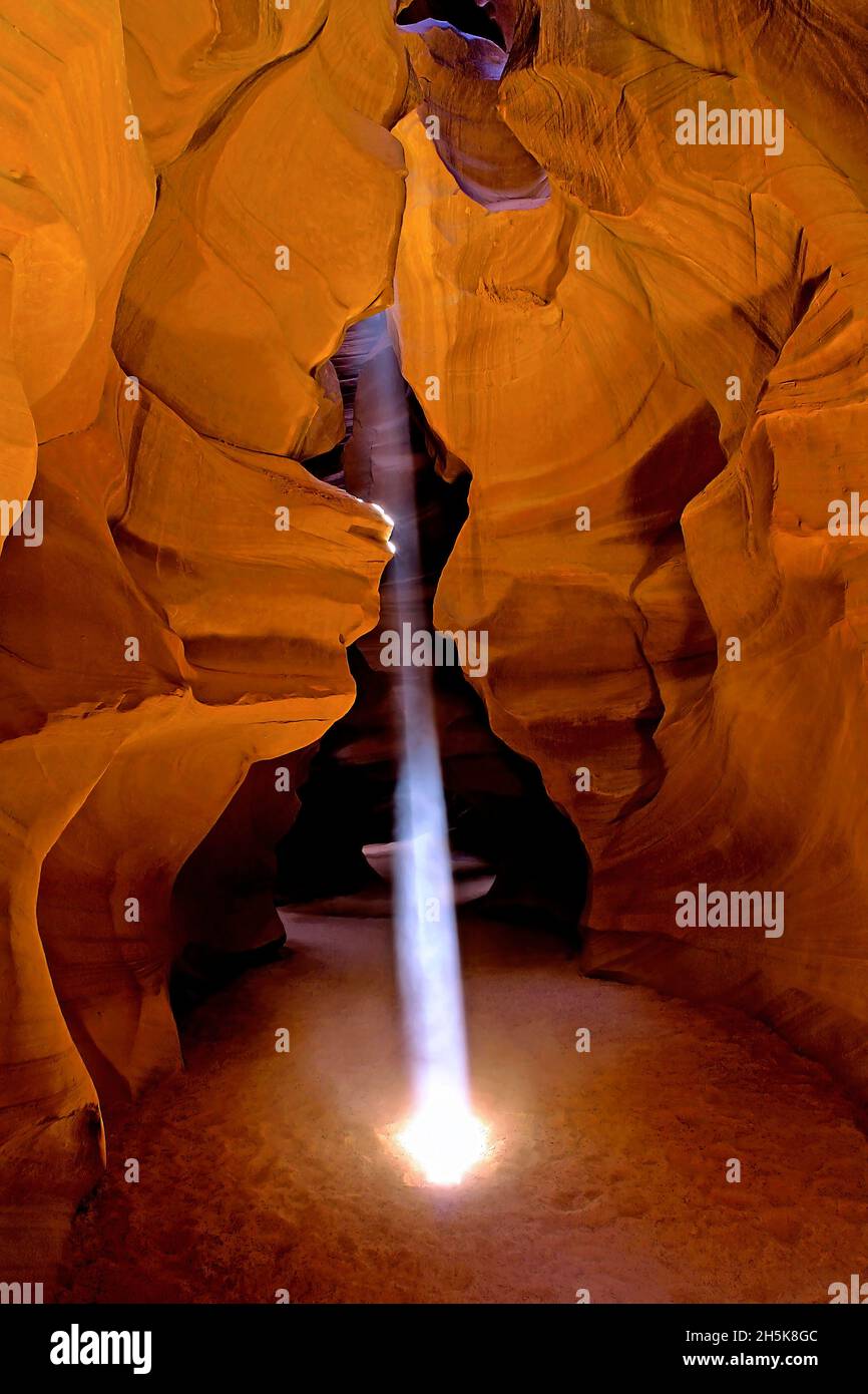 Shaft of light creates a glowing beam in a slot canyon in Antelope Canyon; Arizona, United States of America Stock Photo
