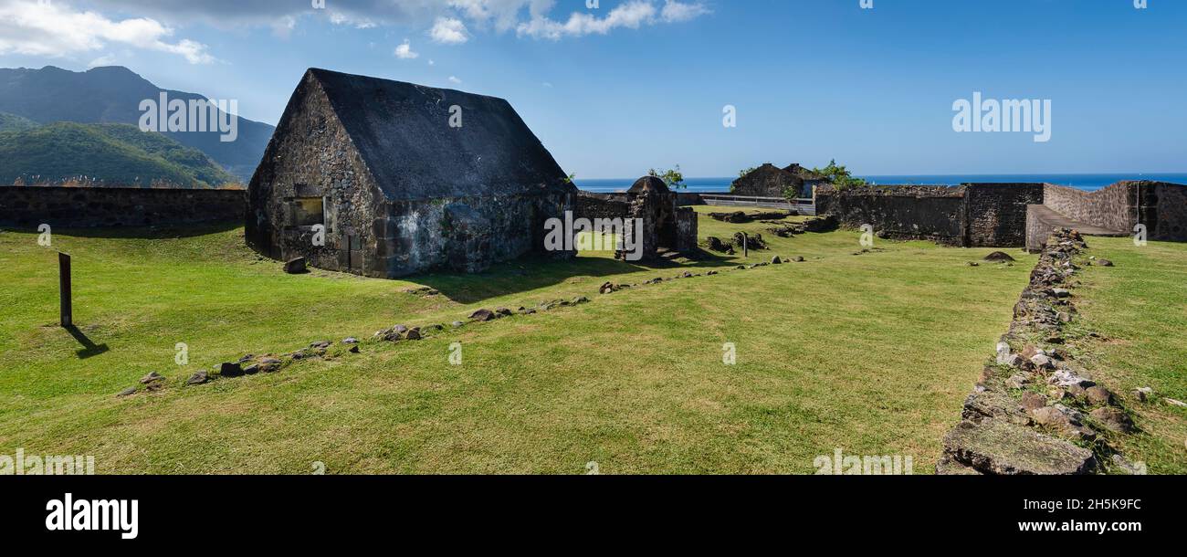 Stone building in a field with the surrounding defense wall at Fort Louis Delgres; Basse-Terre, Guadeloupe, French West Indies Stock Photo