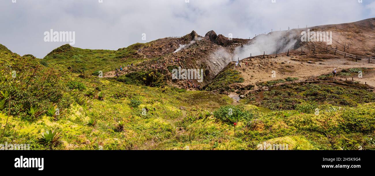 People hiking along the mountain trail near the top of the La Grande Soufriere  with it's crater emitting gases, Basse-Terre Stock Photo