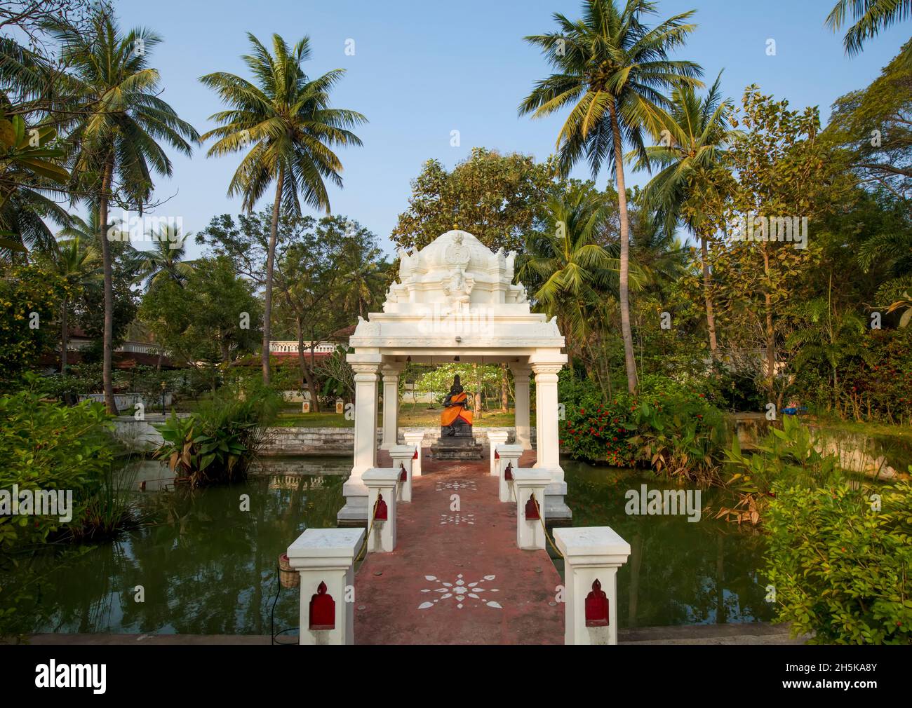 Hindu shrine with a statue of a deity wrapped in orange silk in the rural village at CGH Earth property of Mantra Koodam in Kumbakonam Stock Photo