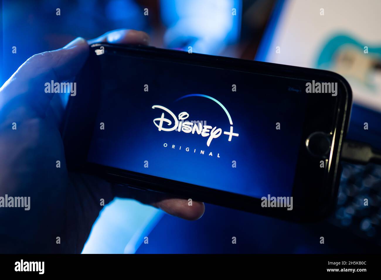 Bangkok, Thailand - November 10, 2021 :A mobile user using Disney+, a video streaming service app, on iPhone 7. Stock Photo