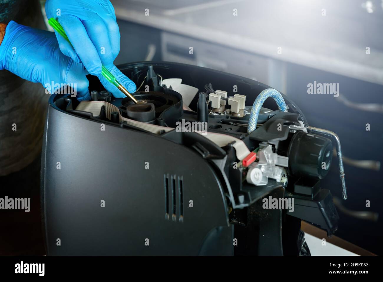 A repairman fixes a broken coffee maker, repair of household appliances Stock Photo