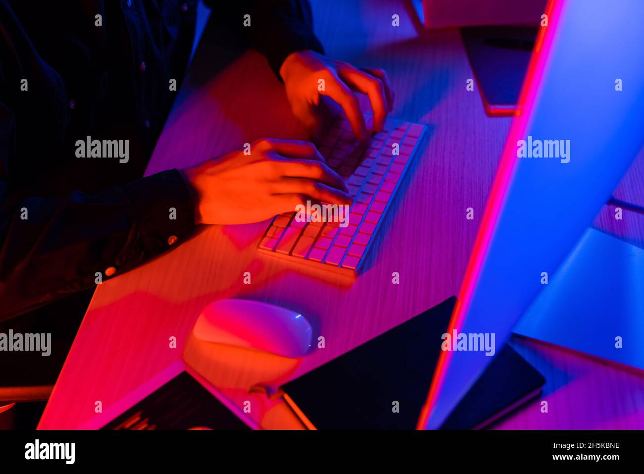 Cropped view of programmer using computer near notebook on table Stock Photo