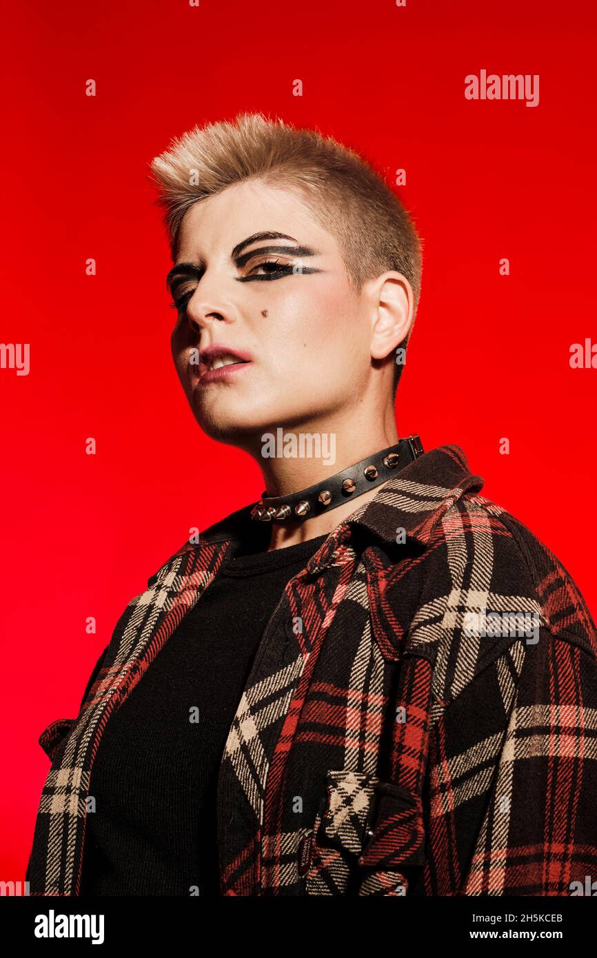 Short hair blonde rock girl on a red background Stock Photo - Alamy
