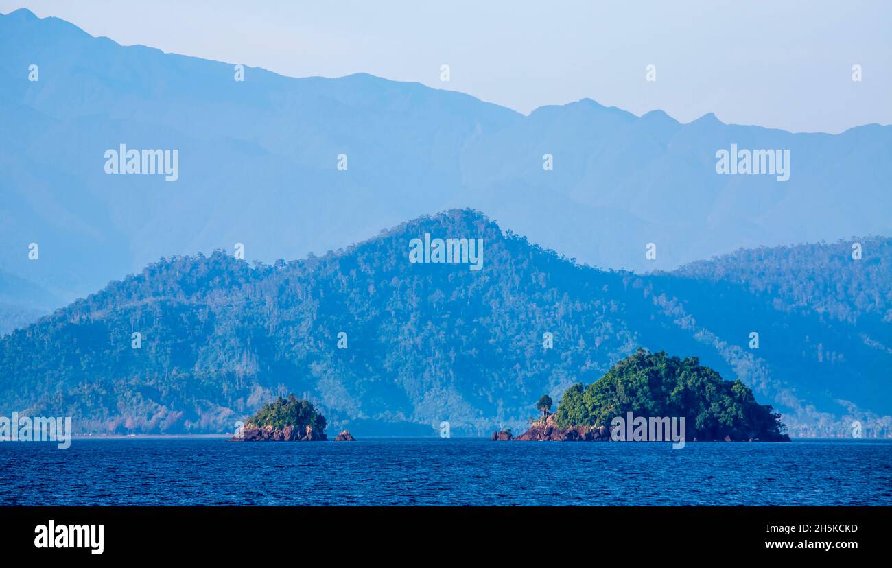 Vista of rainforest covered coast, hills and islands from the Solomon Sea off the shore of Morobe Province, Papua New Guinea Stock Photo