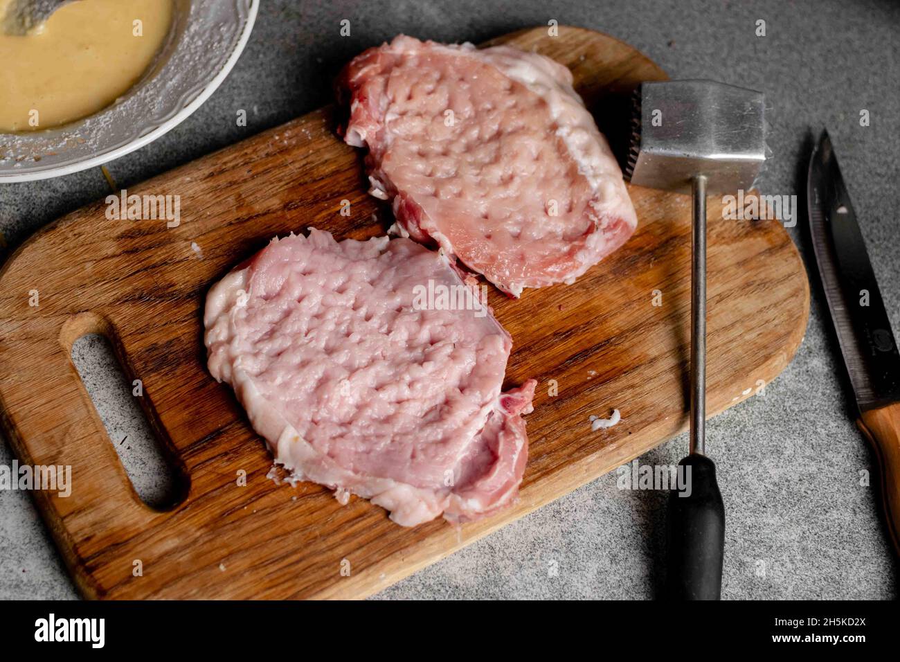 Two pieces of beaten meat on a cutting board. Cooking pork chops Stock ...