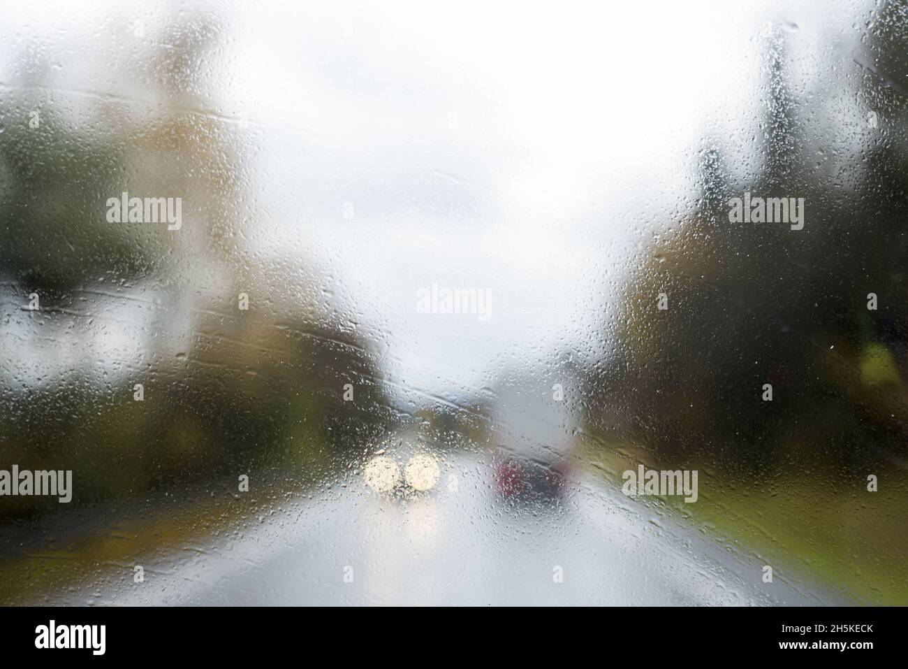 Driving with no windscreen wipers in heavy rain with traffic. Unwiped rain water off
