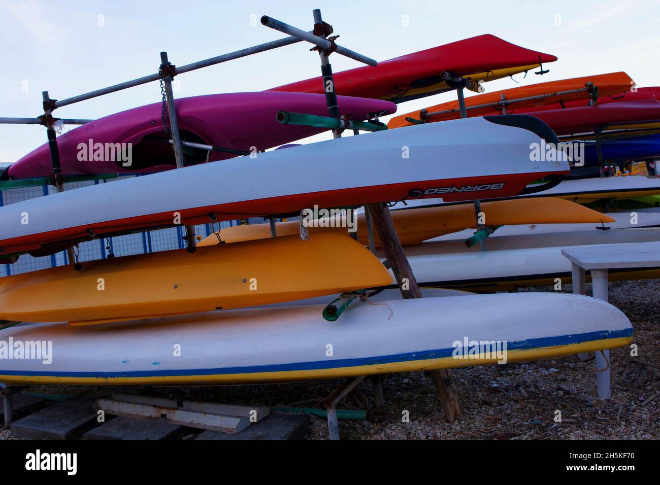 Gestapelte Surfbretter und Kanus in verschiedenen Farben, Italien. Stock Photo