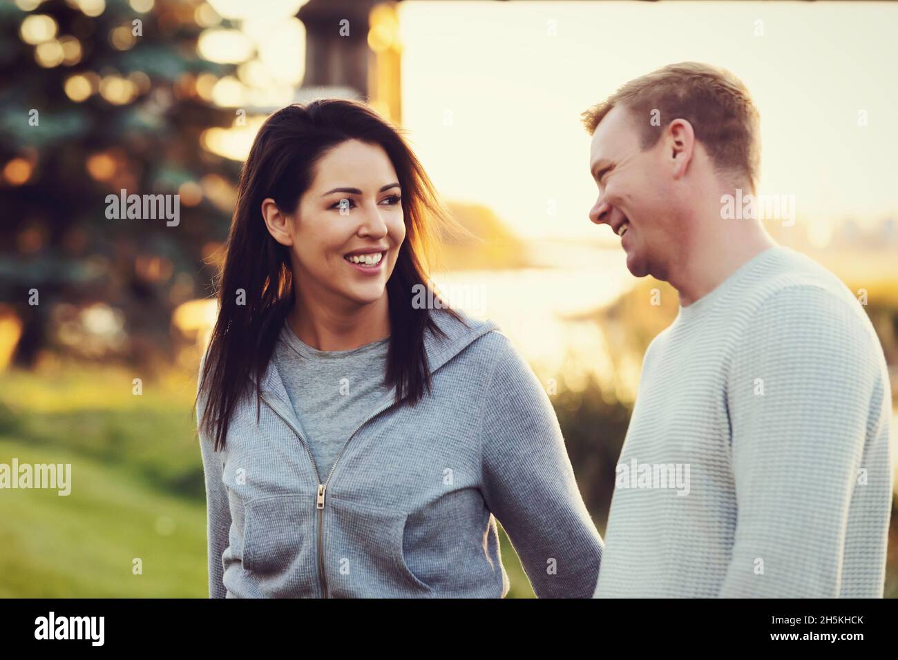 A mid adult couple walking and talking together in a park in autumn; St. Albert, Alberta, Canada Stock Photo