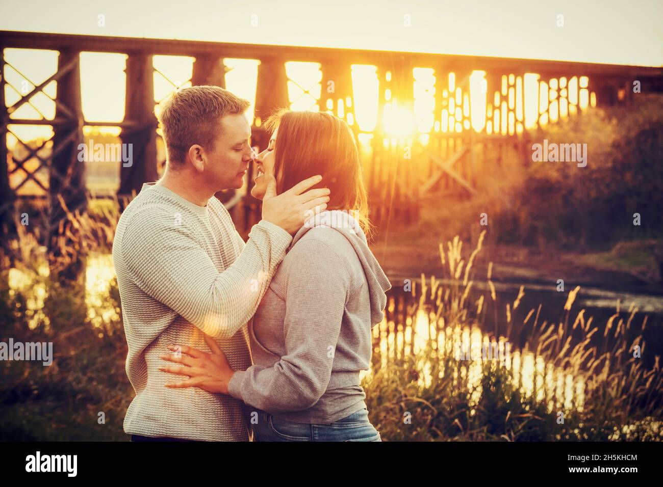 A mid adult couple sharing an intimate moment at sunset in a park in autumn; St. Albert, Alberta, Canada Stock Photo