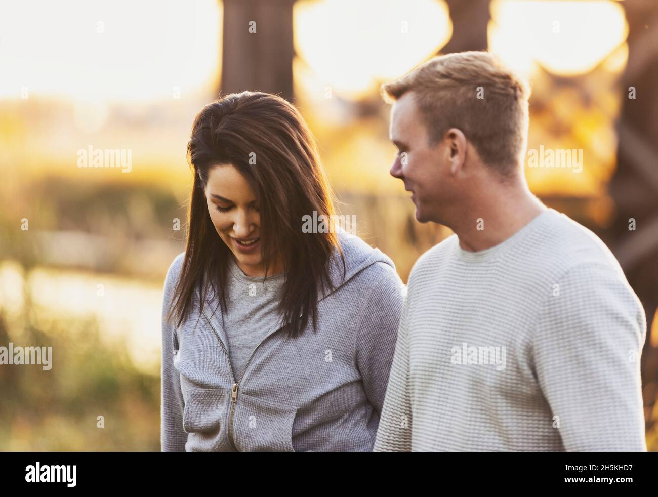 A mid adult couple walking and talking together in a park in autumn; St. Albert, Alberta, Canada Stock Photo