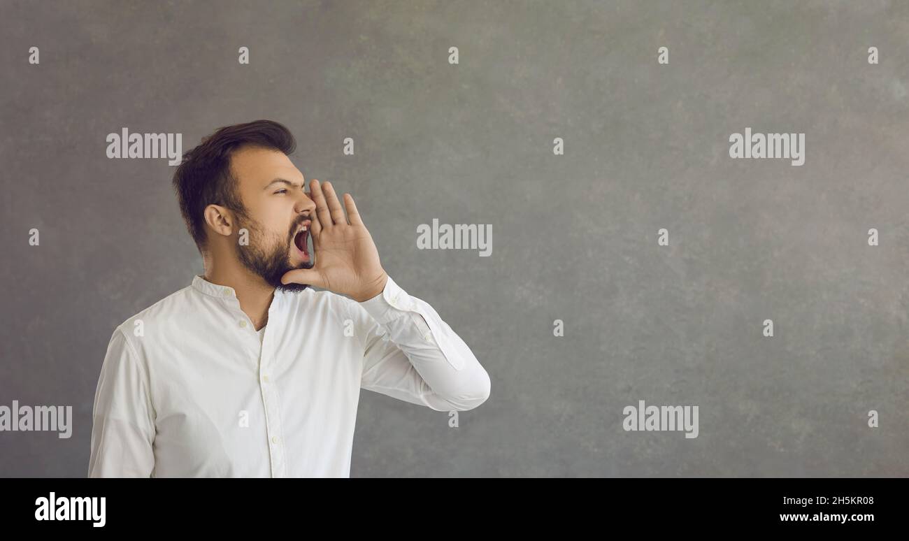 Caucasian man loudly announces advertisements, news or information about discounts. Stock Photo