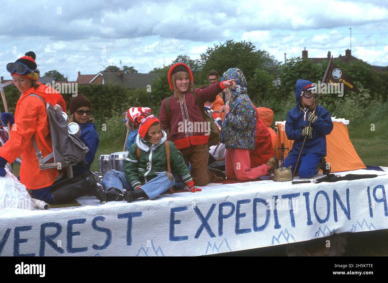 1977, historical, celebrating the Queen's Silver Jubliee, girls in anoraks and camping gear from the 1st Tilston girl guides sitting on a decorated trailer or float, named after the Everest Expedition of the same year, Tilston, Cheshire, England, UK. Stock Photo