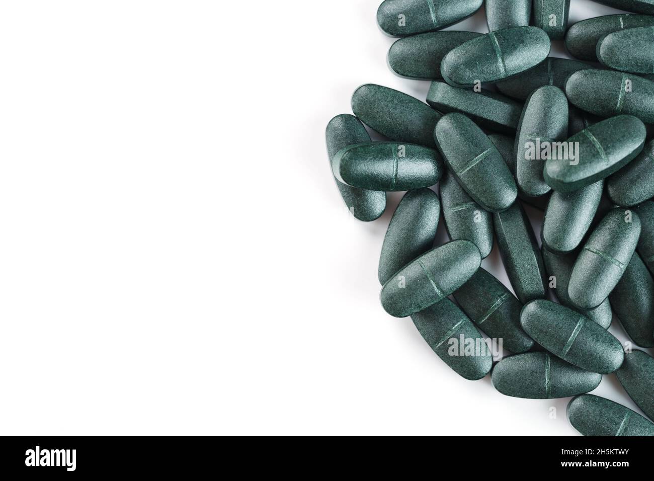 Green spirulina pills with multivitamins on a white background. Free space Stock Photo Alamy